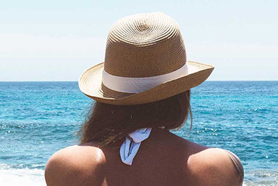 Serene beach scene with tan woman looking out to water